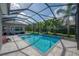 Sparkling pool in screened enclosure features a decorative waterfall and patio at 6915 Sea Stone Ct, Apollo Beach, FL 33572