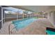 Long view of screened-in pool with light brown stone deck and blue tiled pool at 6958 68Th N Ave, Pinellas Park, FL 33781