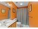 Bathroom features a single sink vanity, toilet, and shower with a curtain and orange walls at 711 S Oregon Ave, Tampa, FL 33606