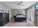 Bedroom with queen-sized bed, dresser, ceiling fan, and access to a balcony with French doors at 711 S Oregon Ave, Tampa, FL 33606