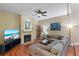 Comfortable living room with hardwood floors, fireplace, fan, and a large sectional couch at 711 S Oregon Ave, Tampa, FL 33606