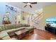Open-concept living room with wood floors, a large sectional, staircase, and stained glass at 711 S Oregon Ave, Tampa, FL 33606