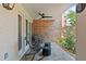 Secluded covered patio featuring rocking chairs, a brick wall, and a ceiling fan at 711 S Oregon Ave, Tampa, FL 33606