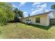 This backyard features a grassy lawn, a shed, patio seating, and mature trees at 712 Hazy Meadow Ct, Brandon, FL 33510