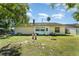 This backyard features a grassy lawn, a shed, patio seating, and mature trees at 712 Hazy Meadow Ct, Brandon, FL 33510