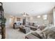 Spacious living room featuring plush gray seating and soft carpeting for a comfortable and inviting atmosphere at 7836 Yale Harbor Dr, Wesley Chapel, FL 33545