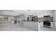 A modern kitchen with stainless steel appliances, a decorative backsplash, bar seating, and white cabinetry at 9306 Forest Hills Dr, Tampa, FL 33612