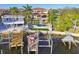 Aerial view of a stunning home with waterfront access, a private dock, and a sparkling pool in the backyard at 100 Driftwood W Dr, Palm Harbor, FL 34683
