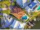 Aerial view showcasing a house with a terracotta roof, a private pool, and its waterfront location at 100 Driftwood W Dr, Palm Harbor, FL 34683