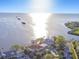 Stunning aerial view of waterfront homes and a beautiful bay with the sun shining over the water at 100 Driftwood W Dr, Palm Harbor, FL 34683