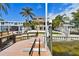 Stunning backyard view featuring a house with palm trees and a dock at 100 Driftwood W Dr, Palm Harbor, FL 34683