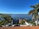 Aerial backyard view of the Intracoastal with dock, pool, and lush palm trees at 100 Driftwood W Dr, Palm Harbor, FL 34683