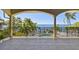 Tiled balcony overlooking the landscaped backyard with swimming pool and bay at 100 Driftwood W Dr, Palm Harbor, FL 34683