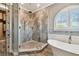 Bathroom showcasing glass shower, soaking tub and arched windows at 100 Driftwood W Dr, Palm Harbor, FL 34683