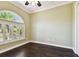 Bedroom with a large window with shutter, hardwood floor, and neutral-colored walls at 100 Driftwood W Dr, Palm Harbor, FL 34683