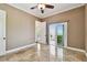 An airy bedroom with a ceiling fan, tiled flooring, and sliding door access to the outdoor balcony at 100 Driftwood W Dr, Palm Harbor, FL 34683
