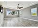 This bedroom features gray plank flooring, a ceiling fan, and picturesque water views at 100 Driftwood W Dr, Palm Harbor, FL 34683