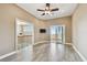 Bright bedroom with wood-look tile floor, ceiling fan, and sliding doors to the outdoor balcony at 100 Driftwood W Dr, Palm Harbor, FL 34683