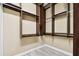 Walk-in closet with custom shelving and gray wood-look tile flooring at 100 Driftwood W Dr, Palm Harbor, FL 34683
