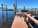 Beautiful waterfront dock with boat lift and tranquil water views on a sunny day at 100 Driftwood W Dr, Palm Harbor, FL 34683