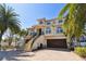 Stunning waterfront home featuring a two-car garage, an elevated front porch, and lush landscaping at 100 Driftwood W Dr, Palm Harbor, FL 34683