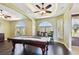 Bright game room features a billiard table, wood floors, and arched windows with plantation shutters at 100 Driftwood W Dr, Palm Harbor, FL 34683