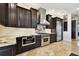 Modern kitchen featuring stainless appliances, granite counters, and dark wood cabinetry at 100 Driftwood W Dr, Palm Harbor, FL 34683
