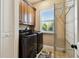 Well-equipped laundry room featuring modern washer and dryer, storage, and natural light from the window at 100 Driftwood W Dr, Palm Harbor, FL 34683