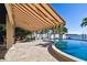 Poolside patio features outdoor dining and a covered awning overlooking picturesque waterfront views for relaxation at 100 Driftwood W Dr, Palm Harbor, FL 34683