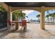 Covered patio with dining area overlooking the pool and tropical backyard at 100 Driftwood W Dr, Palm Harbor, FL 34683