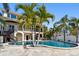 Stunning backyard pool surrounded by palm trees, offering a tropical oasis for relaxation and entertainment at 100 Driftwood W Dr, Palm Harbor, FL 34683