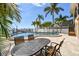 Backyard with a pool, palm trees, and an outdoor seating area, creating a tropical oasis at 100 Driftwood W Dr, Palm Harbor, FL 34683