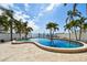 Travertine patio surrounds this kidney-shaped swimming pool lined by lush palms, with ocean views and a dock at 100 Driftwood W Dr, Palm Harbor, FL 34683