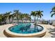 Inviting backyard pool with lush palm trees and waterfront views, creating a serene outdoor space at 100 Driftwood W Dr, Palm Harbor, FL 34683
