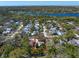 An aerial view shows this home nestled in a mature treed neighborhood with beautiful lake views at 1220 Parkview Ln, Largo, FL 33770