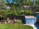 Backyard featuring storage shed, mature trees, and well-maintained landscaping at 1220 Parkview Ln, Largo, FL 33770