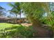 Manicured backyard featuring lush green grass, tropical foliage, and a patio at 1220 Parkview Ln, Largo, FL 33770