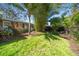 A grassy backyard adorned with tropical plants, landscaping, and a privacy fence at 1220 Parkview Ln, Largo, FL 33770