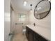Bathroom features updated vanity with modern fixtures, terrazzo floor, and round mirror at 1220 Parkview Ln, Largo, FL 33770