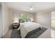 Bedroom featuring a queen-size bed with light blue pillows, modern lamps, and views of tropical trees through windows at 1220 Parkview Ln, Largo, FL 33770