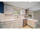 Kitchen featuring white cabinets, stainless steel appliances, and a cozy breakfast bar area at 1220 Parkview Ln, Largo, FL 33770