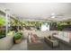 Covered patio with wicker furniture, outdoor ceiling fan, and views of the landscaped backyard with storage shed at 1220 Parkview Ln, Largo, FL 33770