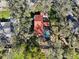 Aerial view of a red-roofed home with a screened-in pool surrounded by mature trees at 14910 Northwood Village Ln, Tampa, FL 33613
