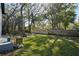 Large backyard with a lush lawn, wooden privacy fence, screened-in porch, and mature trees providing shade at 14910 Northwood Village Ln, Tampa, FL 33613