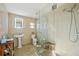 Bright bathroom with a glass shower, pedestal sink, and tiled walls at 14910 Northwood Village Ln, Tampa, FL 33613