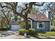 Charming home featuring a brick driveway, attached garage, and mature landscaping at 14910 Northwood Village Ln, Tampa, FL 33613