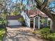 Charming home featuring a brick driveway, attached garage, and a welcoming front entrance with stately columns at 14910 Northwood Village Ln, Tampa, FL 33613