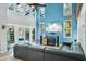 Bright living room featuring soaring ceilings, an entertainment center, a modern gray sofa and outdoor access to the pool at 14910 Northwood Village Ln, Tampa, FL 33613