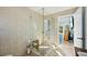Bright, tiled bathroom with glass enclosed shower, and an open doorway to the back patio at 14910 Northwood Village Ln, Tampa, FL 33613