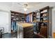 Spacious walk-in closet with custom built-in shelving and a center island with drawers at 14910 Northwood Village Ln, Tampa, FL 33613